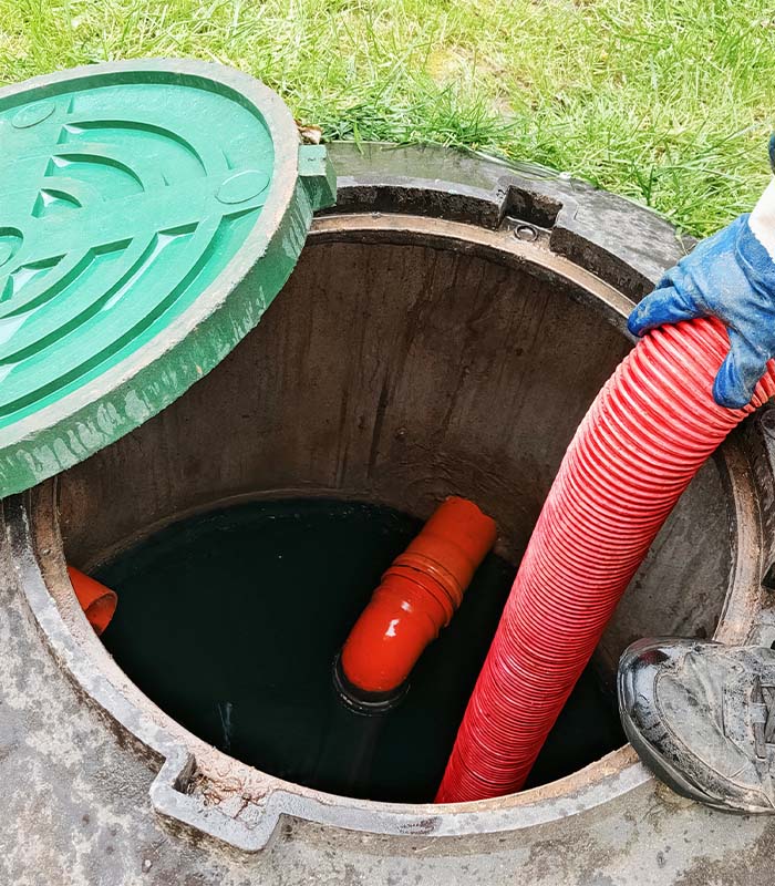 Septic tank service with a hose being used to pump waste in a residential yard