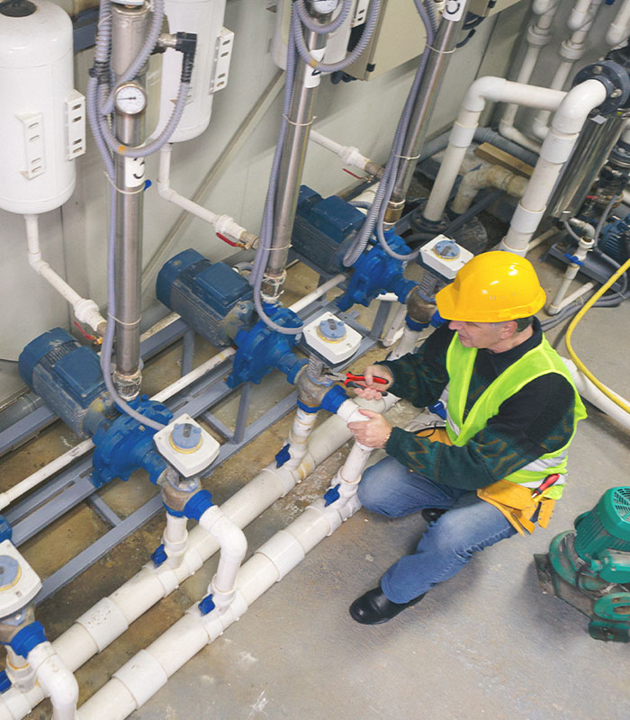 Senior repairman in boiler room checking pipes